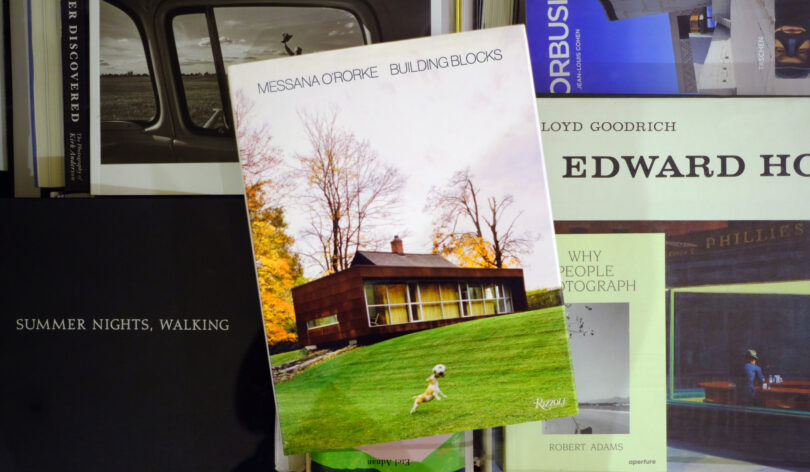 A book titled "Messana O’Rorke: Building Blocks" is propped up among other art and photography books, featured in this Friday 5, with a modern house and dog displayed on its cover.