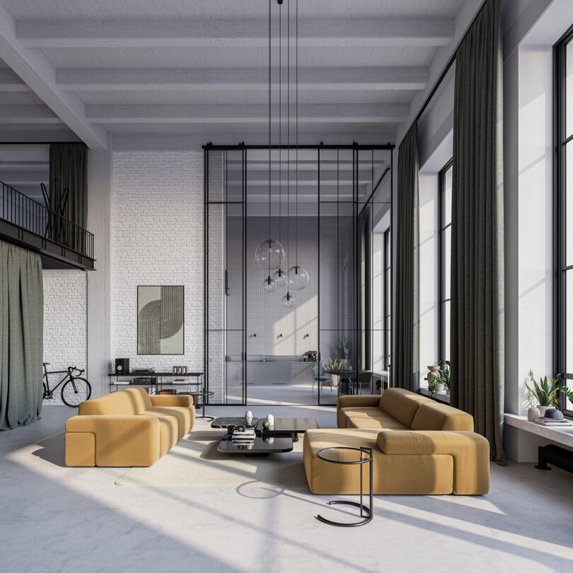 Spacious modern living room with tan sofas, high ceilings, large windows, green curtains, plants, and minimalist decor. A bicycle and mezzanine are visible in the background, showcasing a style inspired by Gabriel Tan.
